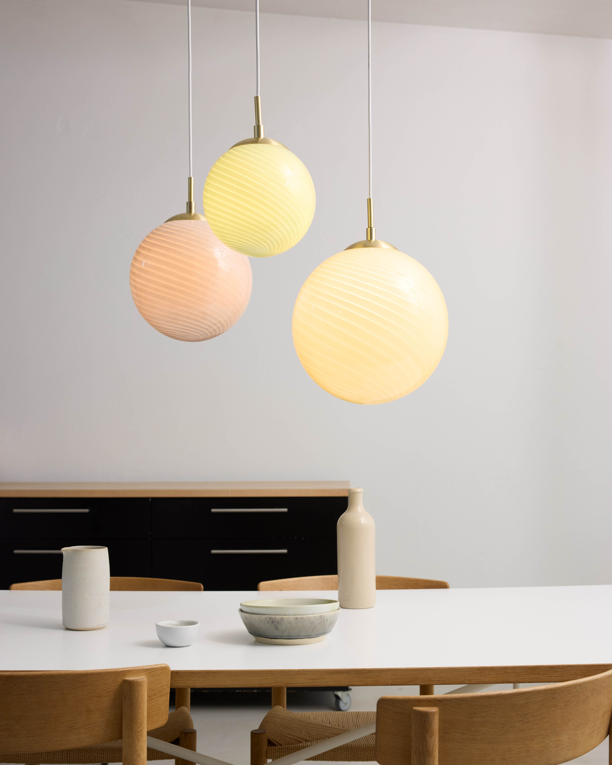 Drie hanglampen boven een eettafel
